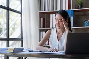 Woman stressed over researching B2B account-based marketing leads.